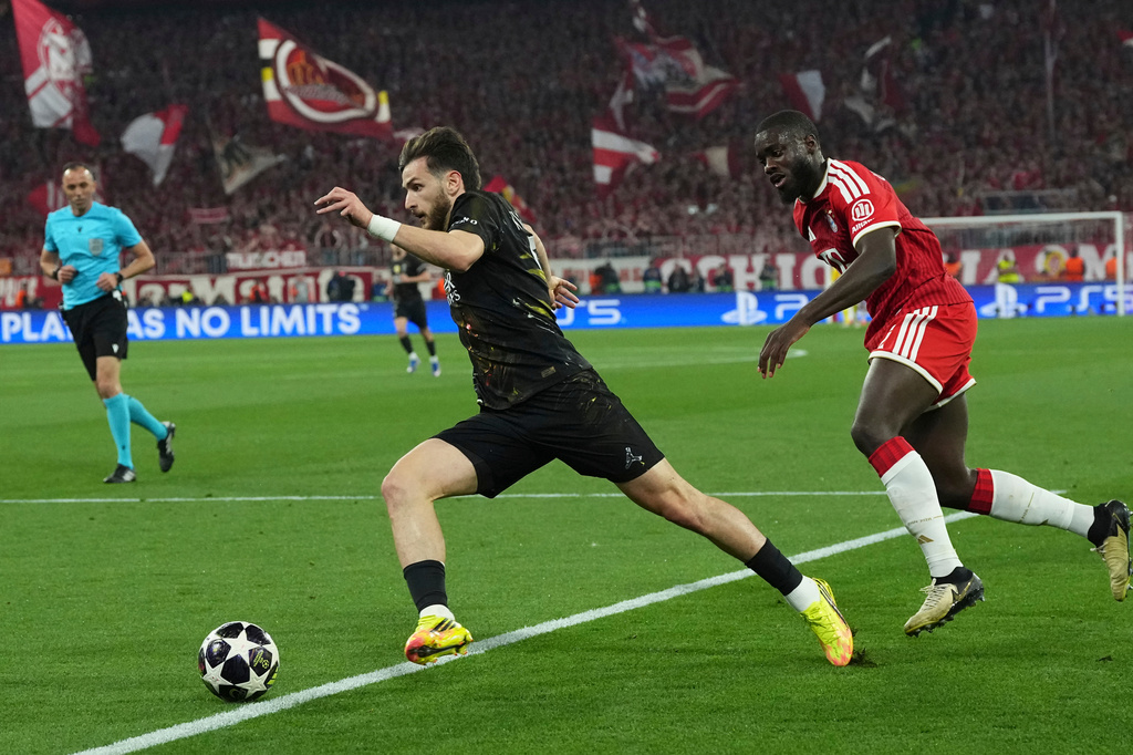 PSG's Khvicha Kvaratskhelia, left, runs with the ball as Bayern's Dayot Upamecano tries to stop him during the Champions League semifinal second leg soccer match between Bayern Munich and Paris Saint Germain in Munich, Germany, Wednesday, May 6, 2026. (AP Photo/Martin Meissner)