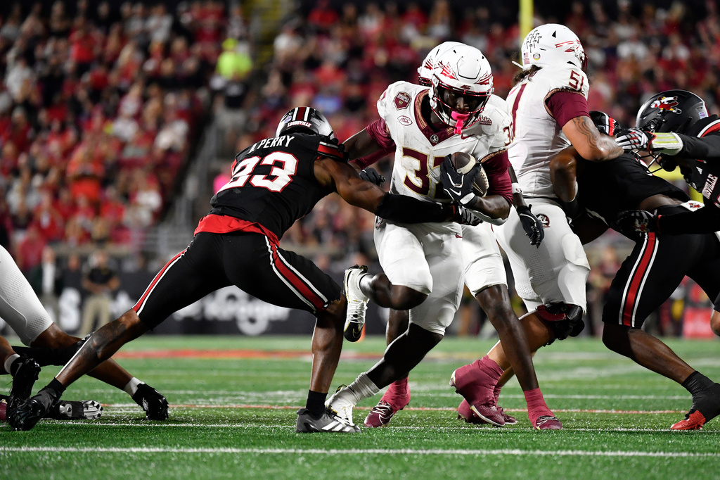 Florida State running back Ousmane Kromah (32) attempts to get past Louisville linebacker Ben Perry (23) during the first half of an NCAA college football game in Louisville, Ky., Friday, Oct. 9, 2026. (AP Photo/Timothy D. Easley)