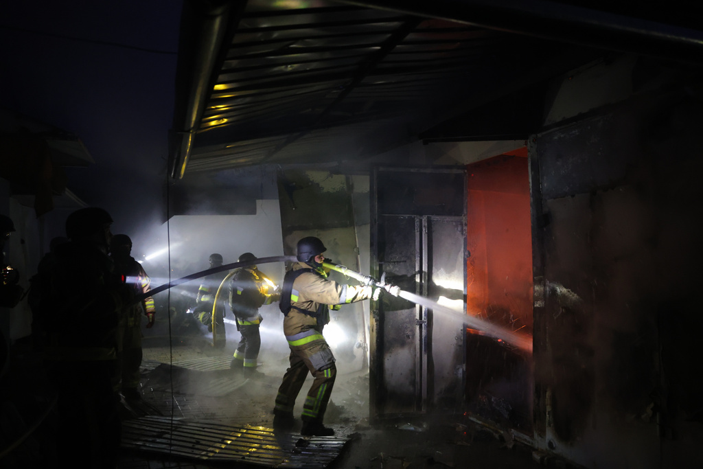 Rescue workers put out a fire at a market destroyed by a Russian airstrike on Zaporizhzhia, Ukraine, Friday, Nov. 21, 2025. (AP Photo/Kateryna Klochko)