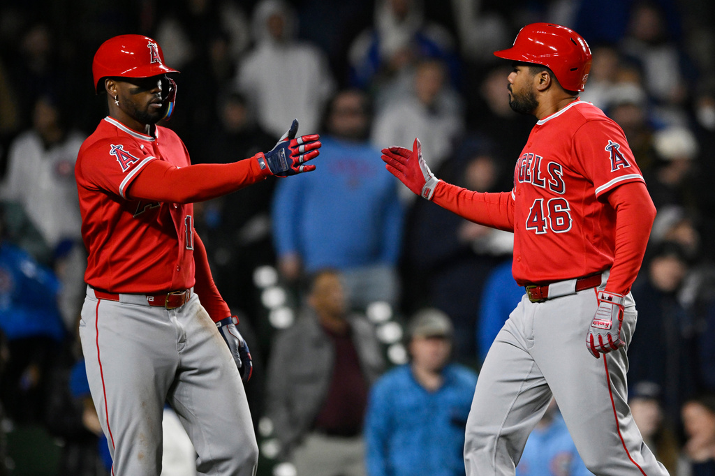 Los Angeles Angels' Jeimer Candelario (46) celebrates with teammate Jorge Soler (12) after scoring on a Logan O'Hoppe single during the sixth inning of a baseball game against the Chicago Cubs in Chicago, Tuesday, March 31, 2026. (AP Photo/Paul Beaty)