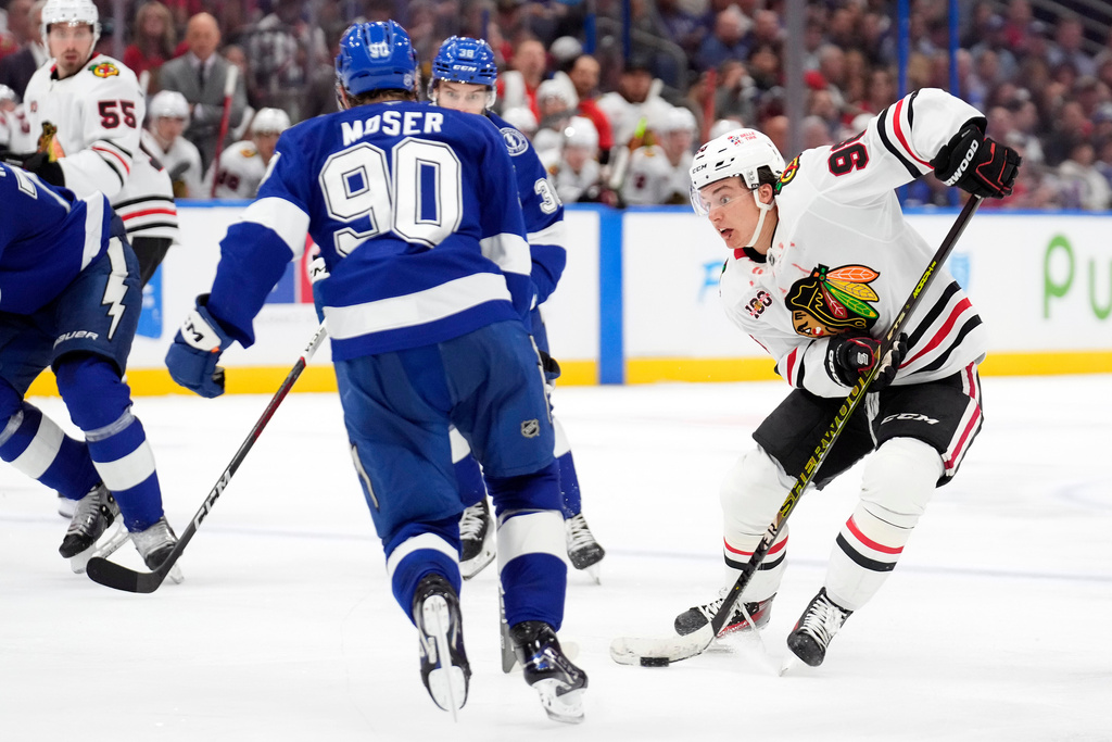 Chicago Blackhawks center Connor Bedard (98) cuts around Tampa Bay Lightning defenseman J.J. Moser (90) during the third period of an NHL hockey game Thursday, Oct. 23, 2025, in Tampa, Fla. (AP Photo/Chris O'Meara)