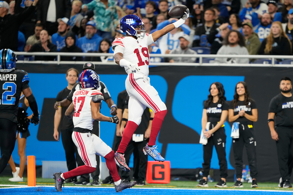 New York Giants quarterback Jameis Winston (19) celebrates his touchdown catch against the New York Giants as New York Giants wide receiver Wan'Dale Robinson (17) looks on during the second half of an NFL football game in Detroit, Sunday, Nov. 23, 2025. (AP Photo/Ryan Sun)
