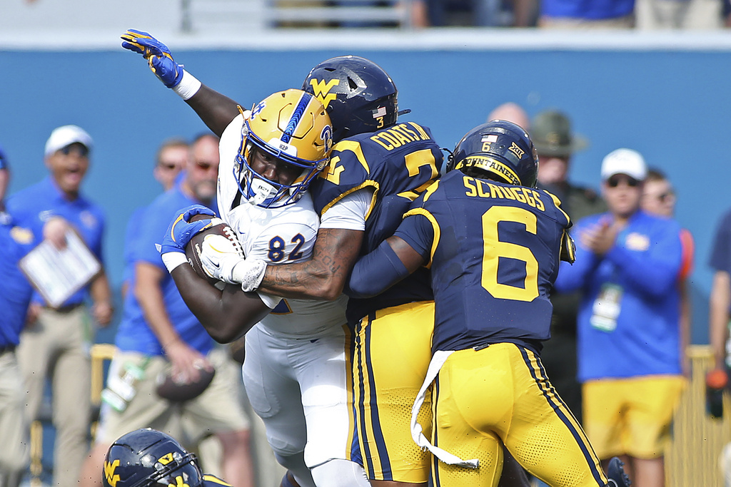 Pittsburgh tight end Malachi Thomas (82) is defended by West Virginia cornerbacks Michael Coats Jr. (3) and Jordan Scruggs (6) during the first half of an NCAA college football game Saturday, Sept. 13, 2025, in Morgantown, W.Va. (AP Photo/Kathleen Batten)