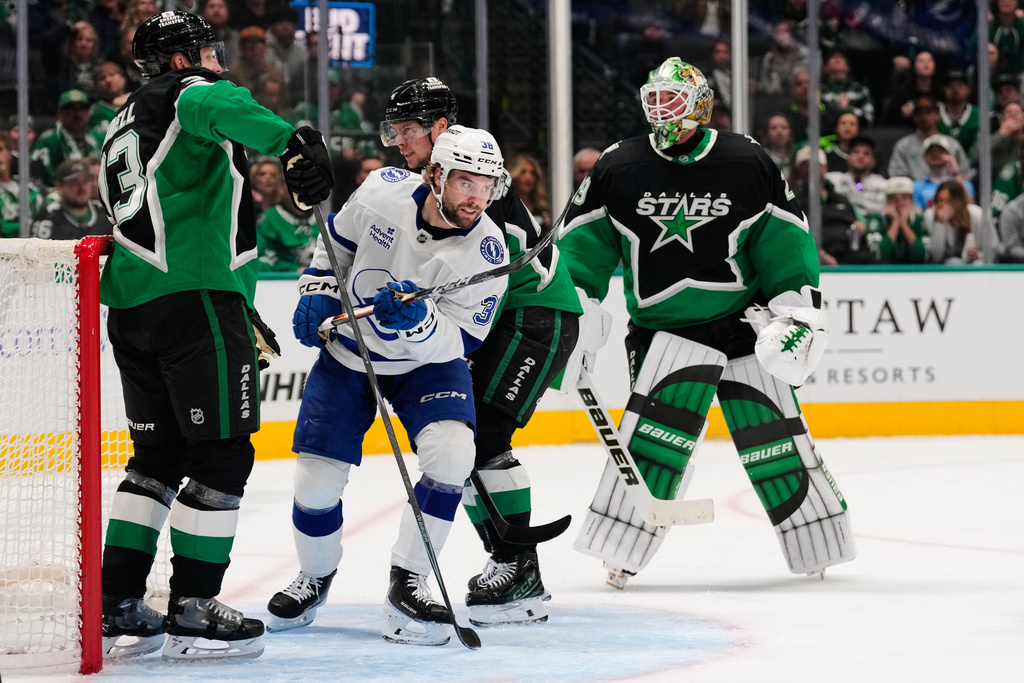 Tampa Bay Lightning left wing Brandon Hagel celebrates his core as Dallas Stars' Esa Lindell, left, Miro Heiskanen, rear, and Jake Oettinger (29) look on in the second period of an NHL hockey game in Dallas, Sunday, Jan. 18, 2026. (AP Photo/Tony Gutierrez)