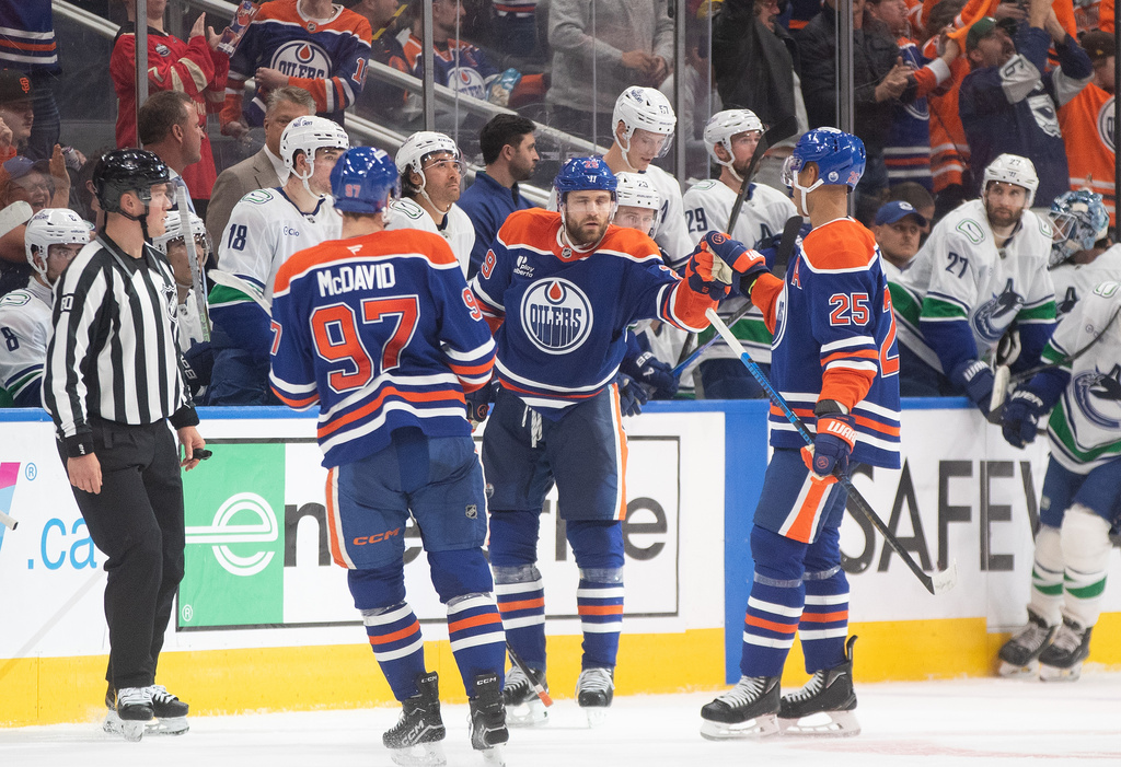 Edmonton Oilers' Connor McDavid (97), Leon Draisaitl (29) and Darnell Nurse (25) celebrate a goal against the Vancouver Canucks the third period of an NHL game in Edmonton on Saturday, Oct. 11, 2025. (Jason Franson/The Canadian Press via AP)