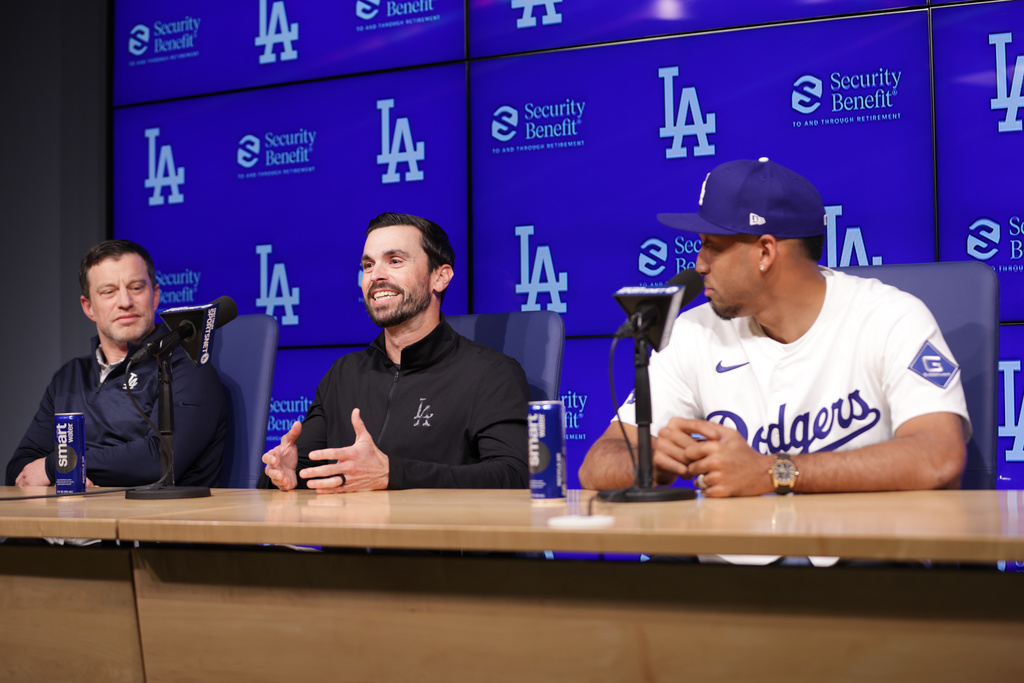 Los Angeles Dodgers General Manager Brandon Gomes, middle, speaks during an introduction of Edwin Díaz, right, as a new member of the baseball team Friday, Dec. 12, 2025, in Los Angeles. (AP Photo/Ethan Swope)
