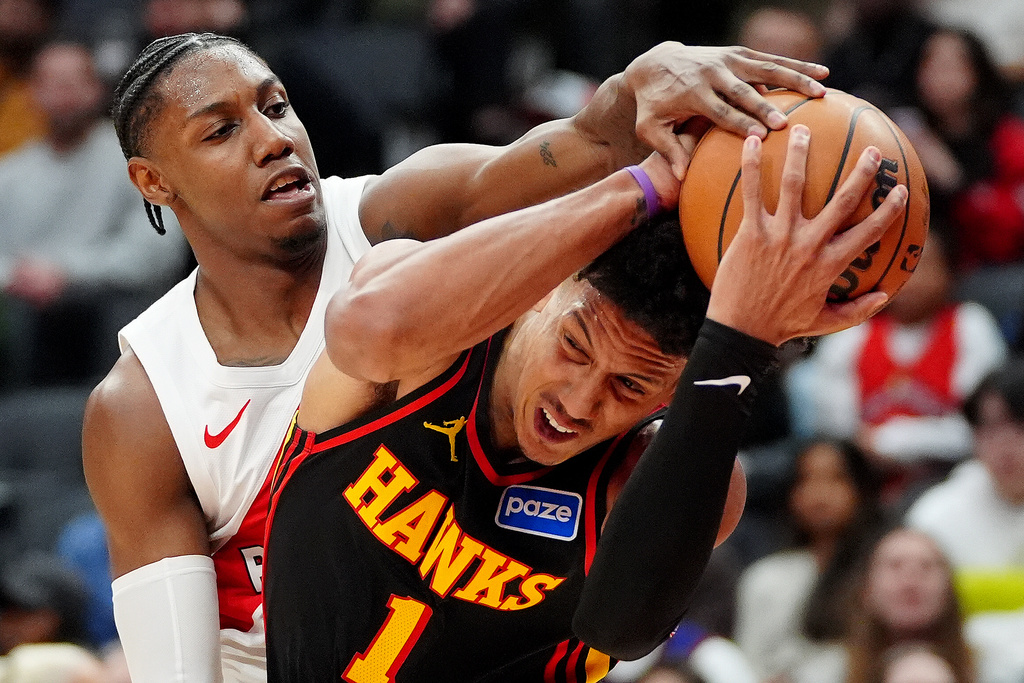 Toronto Raptors forward RJ Barrett, left, tries to strip the ball from Atlanta Hawks forward Jalen Johnson (1) during second-half NBA basketball game action in Toronto, Monday, Jan. 5, 2026. (Frank Gunn/The Canadian Press via AP)
