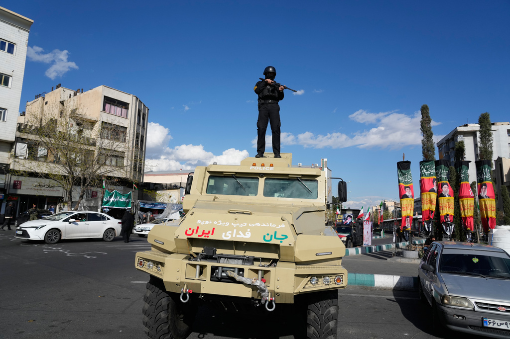 A member of police special forces stands guard on top their car at the Enqelab-e-Eslami, or Islamic Revolution, square in downtown Tehran, Iran, Monday, March 30, 2026. (AP Photo/Vahid Salemi)
