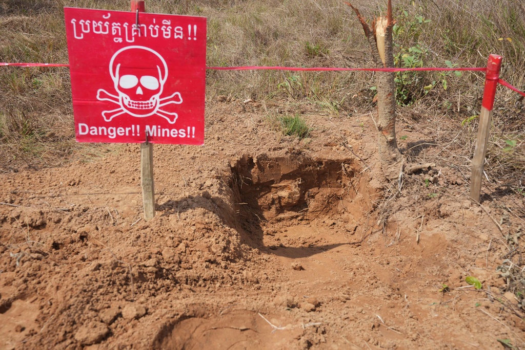 FILE - A "Danger Mines" sign marks an area as Cambodia Mine Action Center, CMAC, staff members work at a minefield in Preytotoeung village, Battambang province, Cambodia, Thursday, Jan. 19, 2023. (AP Photo/Heng Sinith, File)