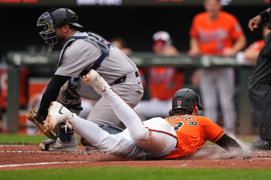Baltimore Orioles' Blaze Alexander, right, scores past New York Yankees catcher J.C. Escarra, left, on a sacrifice fly hit by Adley Rutschman during the third inning of a baseball game, Wednesday, May 13, 2026, in Baltimore. (AP Photo/Stephanie Scarbrough)