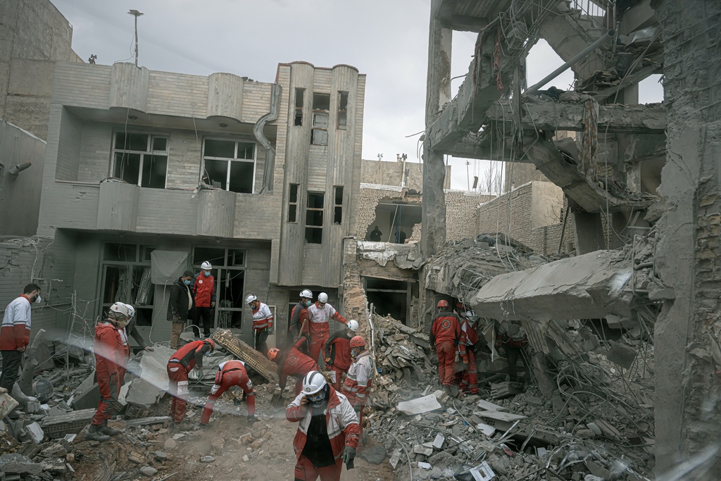 First responders inspect the remains of a residential building hit in an overnight strike during the U.S.-Israeli military campaign in Tabriz, East Azerbaijan Province, northwestern Iran, Tuesday, March 24, 2026. (AP Photo/Matin Hashemi)