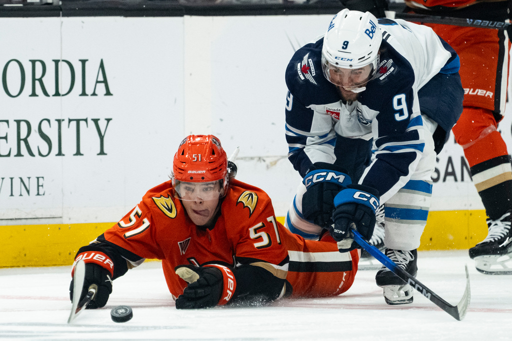 Anaheim Ducks defenseman Olen Zellweger, left, and Winnipeg Jets left wing Alex Iafallo (9) vie for the puck during the second period of an NHL hockey game, Friday, Feb. 27, 2026, in Anaheim, Calif. (AP Photo/Kyusung Gong)