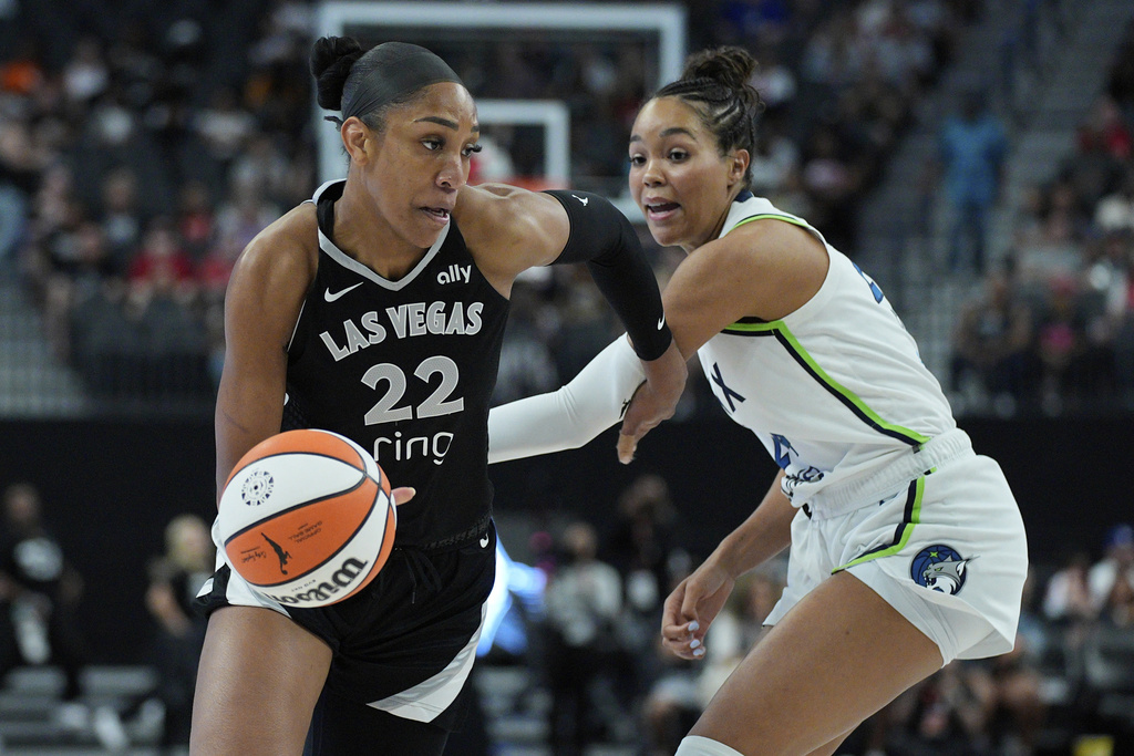Las Vegas Aces center A'ja Wilson (22) drives around Minnesota Lynx forward Napheesa Collier (24) during the first half of a WNBA basketball game Thursday, Sept. 4, 2025, in Las Vegas. (AP Photo/John Locher)
