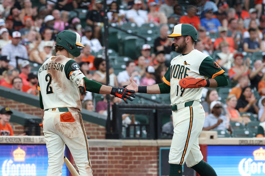 Baltimore Orioles' Colton Cowser, right, is greeted by Gunnar Henderson (2) after scoring on a sacrifice fly hit by Jackson Holliday off San Diego Padres pitcher Griffin Canning during the second inning of a baseball game, Friday, June 12, 2026, in Baltimore. (AP Photo/Terrance Williams)