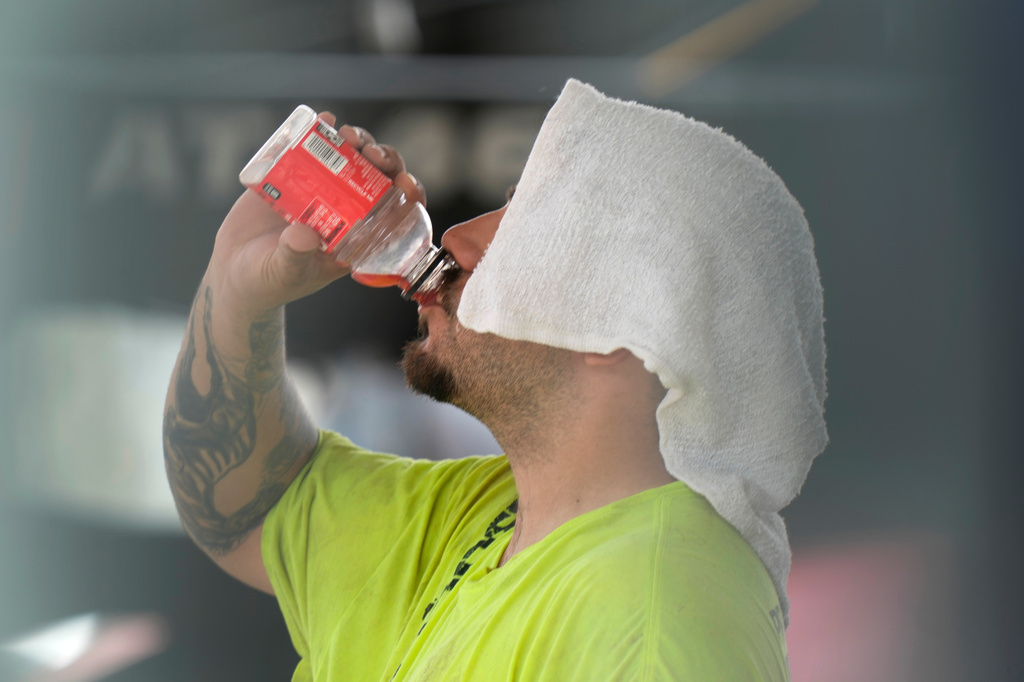 FILE - A construction worker hydrates at the Shedd Aquarium, Aug. 27, 2024, on a hot day in Chicago. (AP Photo/Charles Rex Arbogast, File)