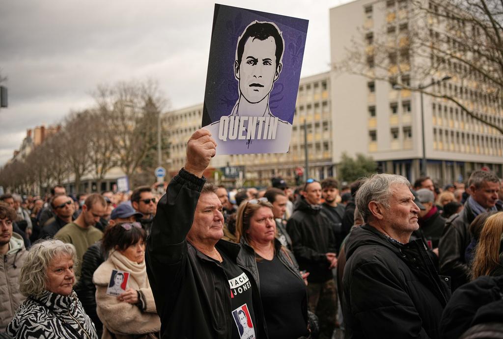 A man hold placard of the killed student as he takes part in a march in Lyon, France, Saturday, Feb. 21, 2026, to pay tribute to Quentin Deranque, a 23-year-old nationalist activist who died from a beating after a clash between far-left and far-right supporters. (AP Photo/Laurent Cipriani)