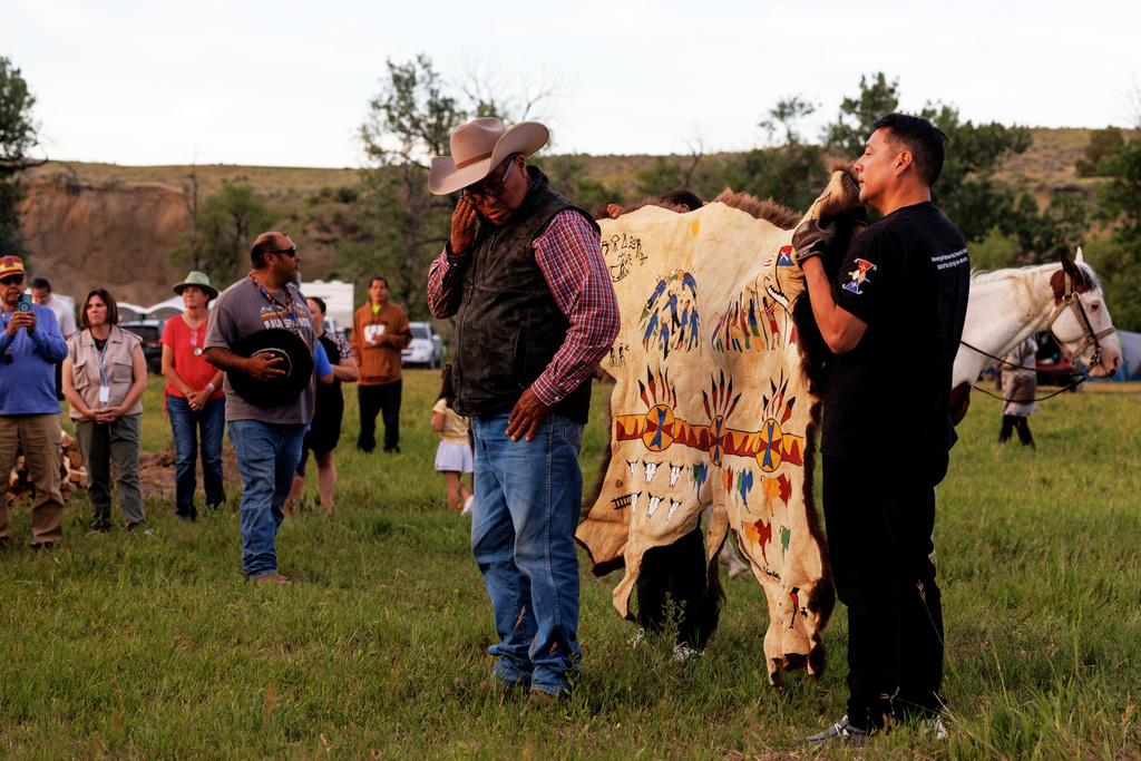 A painted buffalo hide is presented to the Real Bird family during festivities to commemorate the 150th anniversary of the Battle of the Little Bighorn, Wednesday, June 24, 2026, in Crow Agency, Mont. (AP Photo/Tailyr Irvine)