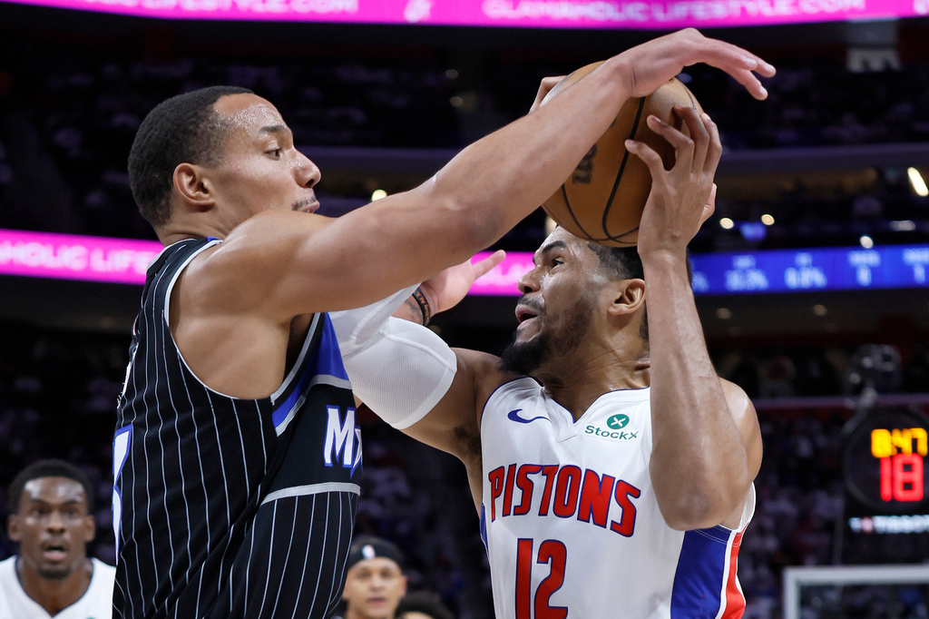 Detroit Pistons forward Tobias Harris (12) is defended by Orlando Magic guard Desmond Bane, front left, during the first half in Game 1 of a first-round NBA basketball playoffs series Sunday, April 19, 2026, in Detroit. (AP Photo/Duane Burleson)