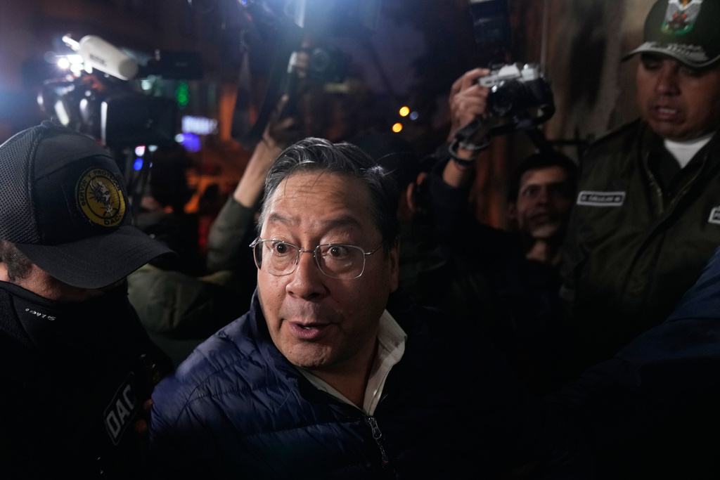 Police officers escort former President Luis Arce to San Pedro Prison after his arrest as part of a corruption investigation in La Paz, Bolivia, Friday, Dec. 12, 2025. (AP Photo/Juan Karita)