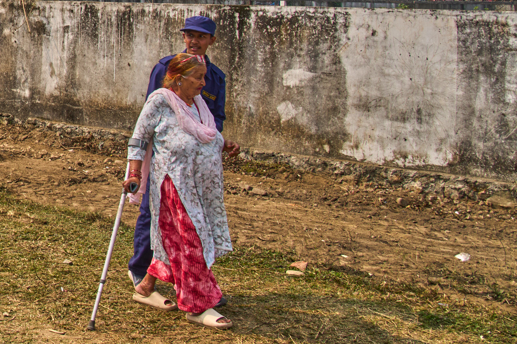 Tulasi Devi Shrestha, 75, a supporter of the Rastriya Swatantra Party, walks to an election rally for prime ministerial candidate and rapper-turned-politician Balendra Shah in Chitwan, approximately 180 kilometers (112 miles) west of Kathmandu, Nepal, Friday, Feb. 27, 2026. (AP Photo/Niranjan Shrestha)