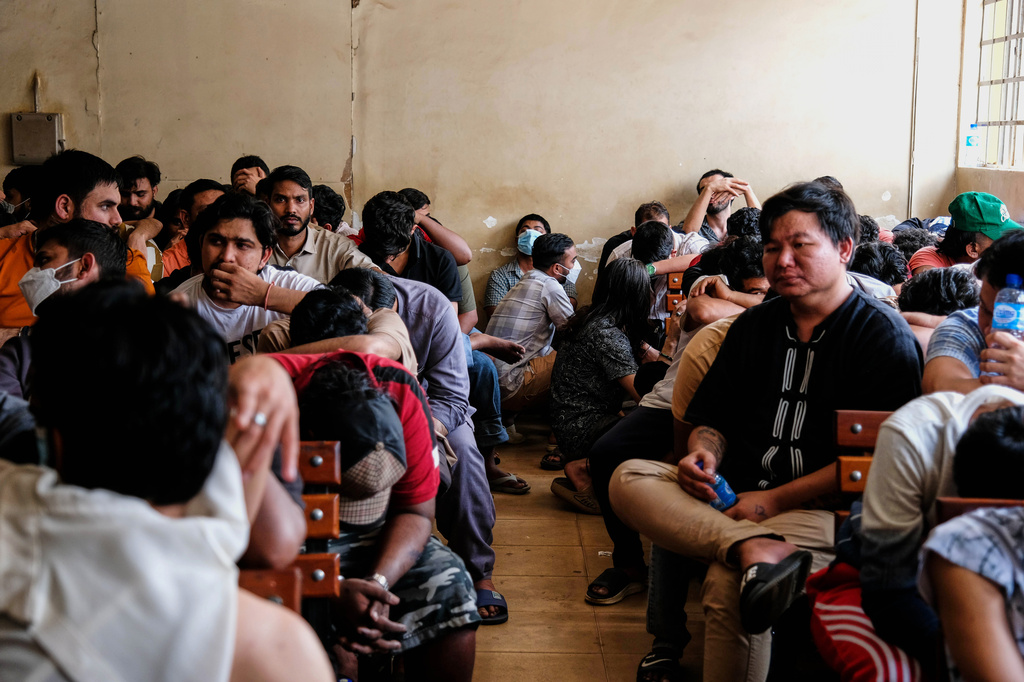 Detainees sit in a room after Ugandan authorities arrested dozens of foreigners in a crackdown on illegal migration in Kampala, Uganda, Tuesday, April 28, 2026. (AP Photo/Hajarah Nalwadda)