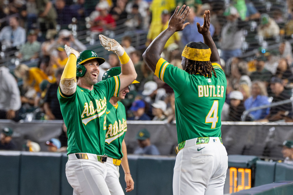 Athletics' Jeff McNeil, left, high-fives Lawrence Butler (4) after hitting a home run during the sixth inning of a baseball game against the Texas Rangers Friday, Aug. 14, 2026, in West Sacramento, Calif. (AP Photo/Sara Nevis)