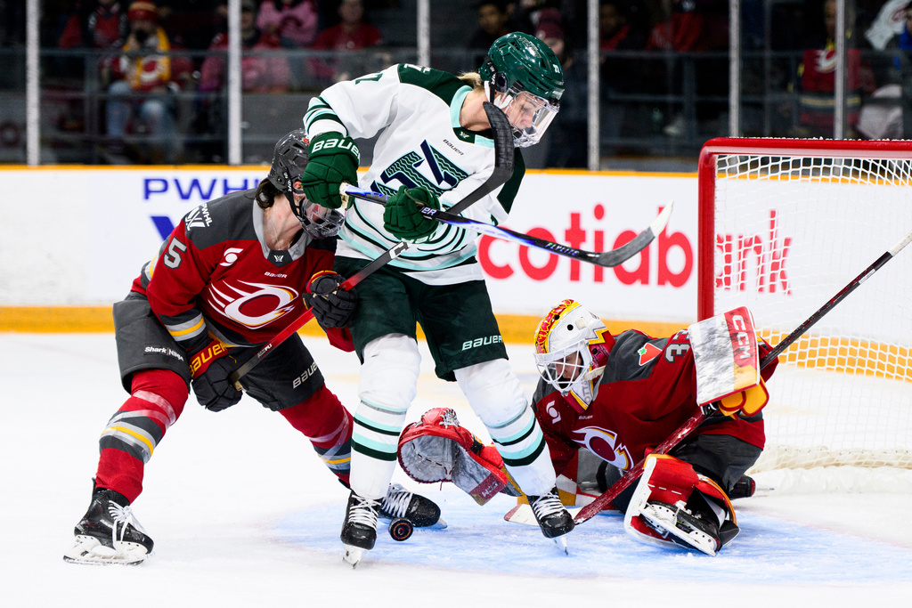 Ottawa Charge goaltender Gwyneth Philips (33) makes a glove save as Boston Fleet's Shay Maloney (27) looks for the puck during the second period of an PWHL hockey game in Ottawa, on Saturday, Dec. 27, 2025. (Spencer Colby/The Canadian Press via AP)