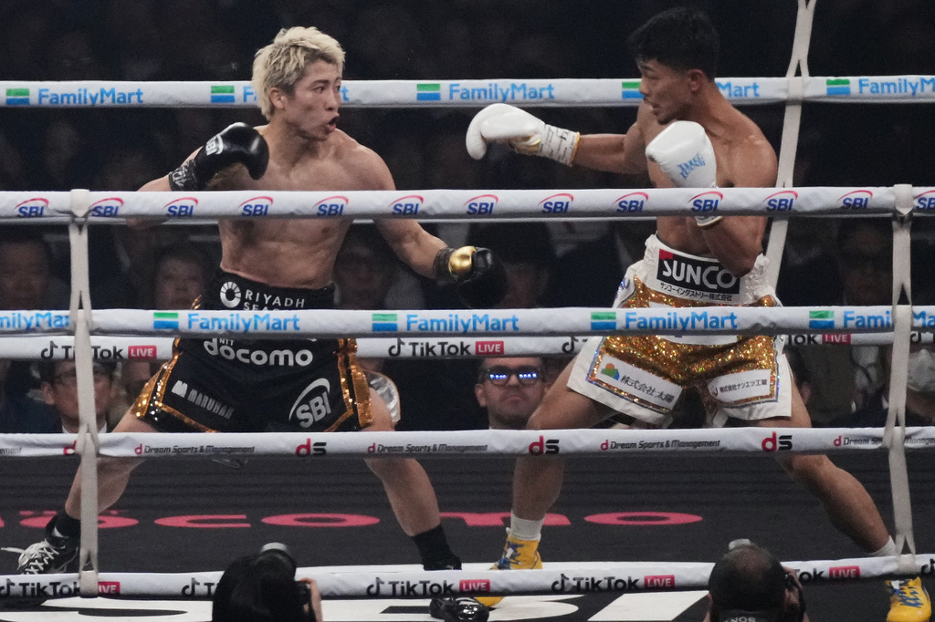 Naoya Inoue of Japan, left, fights Junto Nakatani of Japan during second round of a boxing match for the WBA, WBC, IBF and WBO super bantamweight world title in Tokyo, Saturday, May 2, 2026. (AP Photo/Hiro Komae)