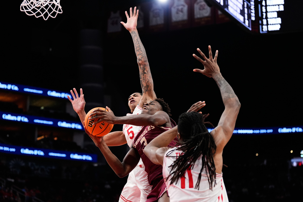 Florida State guard Thomas Bassong (3) shoots against Houston center Chris Cenac Jr. (5) and forward Joseph Tugler (11) during the second half of an NCAA college basketball game in Houston, Saturday, Dec. 6, 2025. (AP Photo/Ashley Landis)