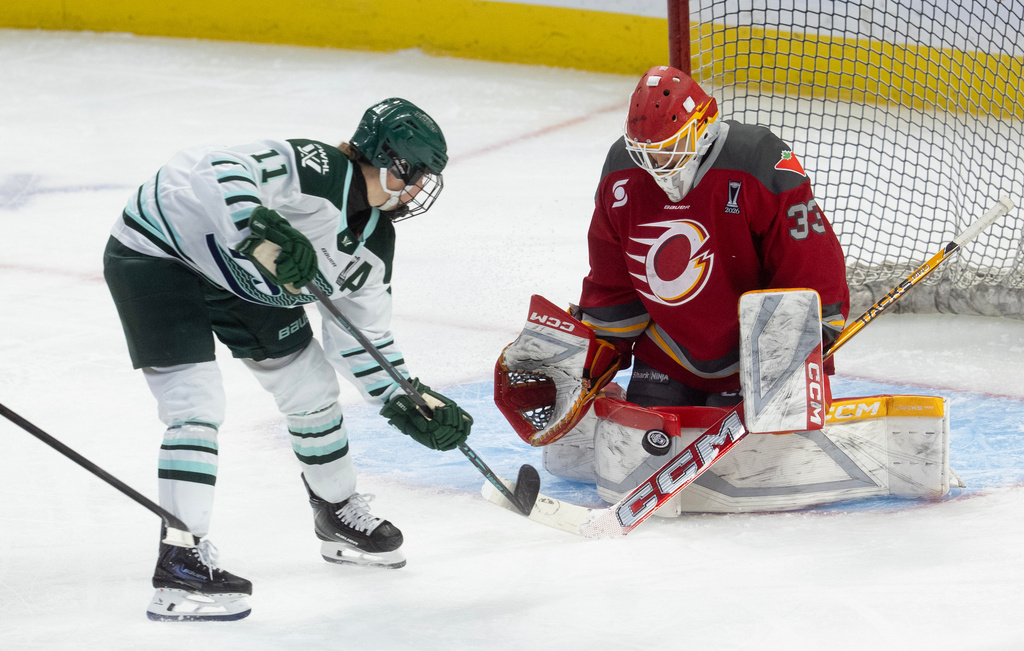 Ottawa Charge goalie Gwyneth Philips (33) makes a save against Boston Fleet forward Alina Muller (11) during the first period of Game 4 in a PWHL hockey playoff series in Ottawa, Ontario, Sunday, May 10, 2026. (Adrian Wyld/The Canadian Press via AP)