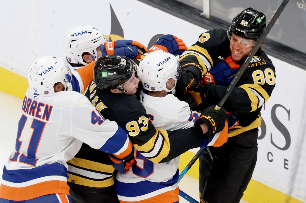 Boston Bruins center Fraser Minten (93) and Boston Bruins right wing David Pastrnak (88) get into a fight with New York Islanders including defenseman Marshall Warren (41) during the third period of an NHL hockey game, Tuesday, Oct. 28, 2025, in Boston. (AP Photo/Mark Stockwell)