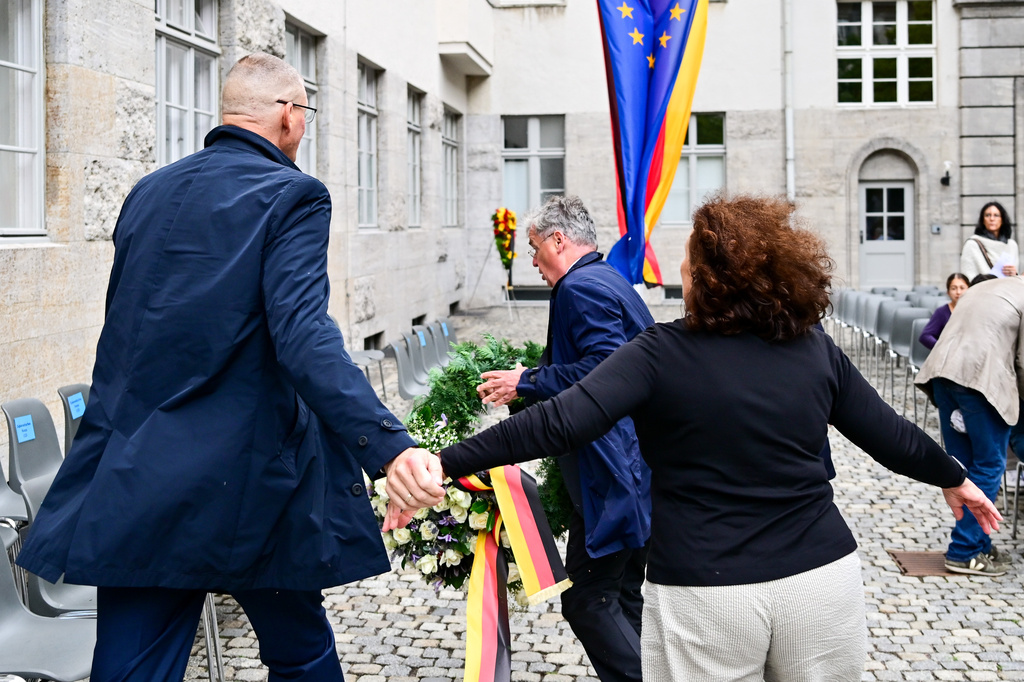Tobias Korenke, center, grandnephew of Dietrich and Klaus Bonhoeffer and grandson of Ruediger Schleicher, try to remove a wreath of Germany's far right AFD party during a memorial event held by the federal government in the courtyard of the Bendlerblock of the Defence Ministry in occasion of the National Day of Remembrance for Resistance Against Nazi regime in Berlin, Monday, July 20, 2026. (Sebastian Christoph Gollnow/dpa via AP)