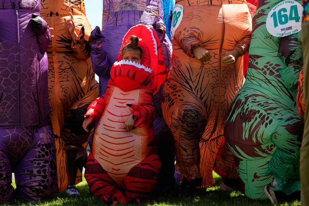 Tilly Sawangwan, 5, stands with other adult T. rex participants during the T-Rex World Championship Races at Emerald Downs, Sunday, July 12, 2026, in Auburn, Wash. (AP Photo/Lindsey Wasson)