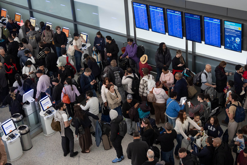 People wait in a TSA line at the John F. Kennedy International Airport, Sunday, March 22, 2026, in New York. (AP Photo/Yuki Iwamura)