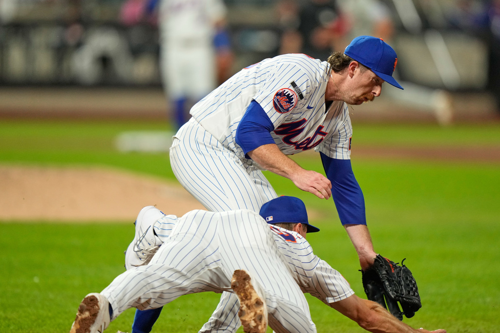 New York Mets pitcher Nolan McLean, top, collides with first baseman Jared Young as they chase a ball during the sixth inning of a baseball game against the Philadelphia Phillies, Thursday, Sept. 17, 2026, in New York. (AP Photo/Seth Wenig)
