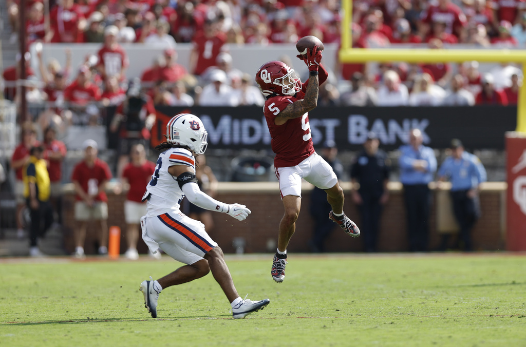 Oklahoma wide receiver Isaiah Sategna III (5) makes a catch in front of Auburn cornerback Raion Strader (13) during the first half of an NCAA college football game Saturday, Sept. 20, 2025, in Norman, Okla. (AP Photo/Alonzo Adams)