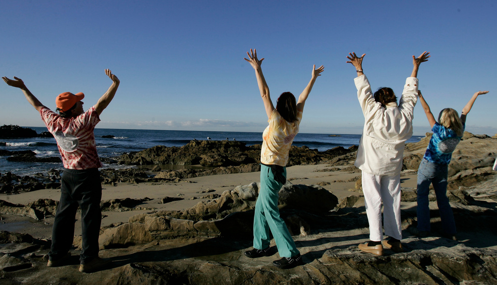 FILE - Class members participate in a laughter yoga class on Main Beach in Laguna Beach, Calif., Nov. 29, 2006. (AP Photo/Chris Carlson, File)