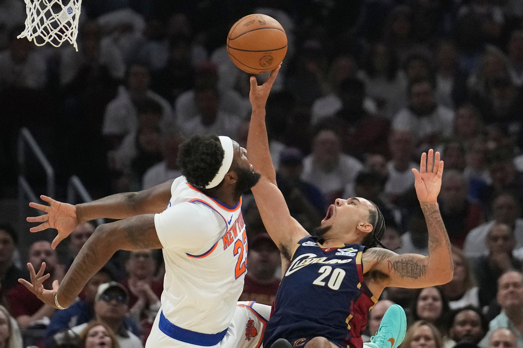 Cleveland Cavaliers guard Jaylon Tyson (20) shoots against New York Knicks center Mitchell Robinson (23) during the first half of Game 3 in the Eastern Conference finals NBA basketball playoffs series in Cleveland, Saturday, May 23, 2026. (AP Photo/Sue Ogrocki)