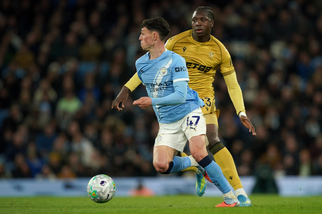 Manchester City's Phil Foden, front, and Crystal Palace's Jaydee Canvot challenge for the ball during the English Premier League soccer match between Manchester City and Crystal Palace in Manchester, England, Wednesday, May 13, 2026. (AP Photo/Ian Hodgson)