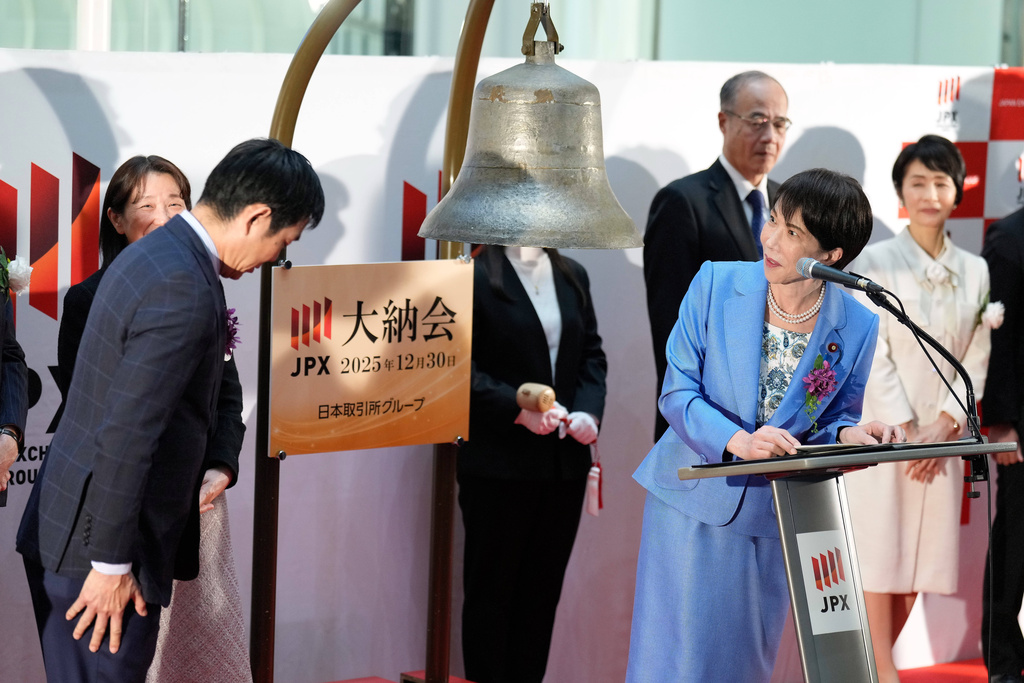 Japan's Prime Minister Sanae Takaichi, right, delivers a speech as Hajime Moriyasu, left, the head coach of Japanese national soccer team, bows during a ceremony to mark the last trading day of the year on the Tokyo Stock ExchangeTuesday, Dec. 30, 2025, in Tokyo. (AP Photo/Eugene Hoshiko)