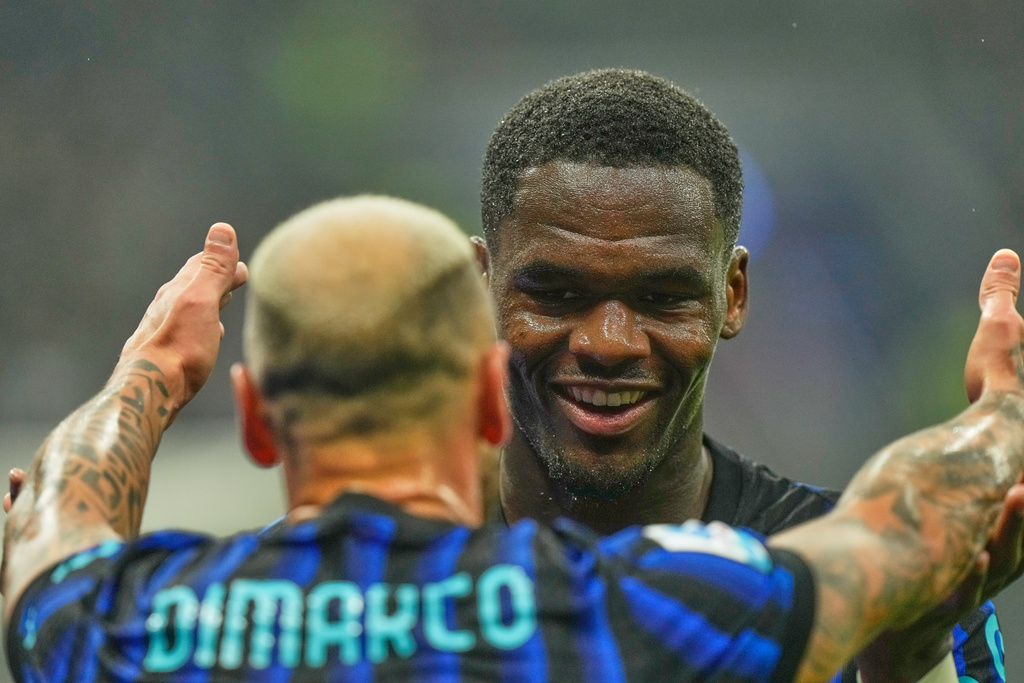 Inter Milan's Ange-Yoan Bonny celebrates with Inter Milan's Federico Dimarco after scoring his side's second goal during the Serie A soccer match between Inter Milan and Cremonese at the San Siro stadium in Milan, Italy, Saturday, Oct. 4, 2025. (AP Photo/Luca Bruno)