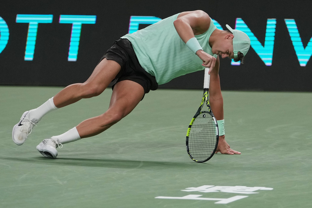 Holger Rune of Denmark stands up after suffering from leg cramps during the men's singles quarterfinals match against Valentin Vacherot of Monaco, at the Shanghai Masters tennis tournament at Qizhong Forest Sports City Tennis Center, in Shanghai, China, Thursday, Oct. 9, 2025. (AP Photo/Andy Wong)