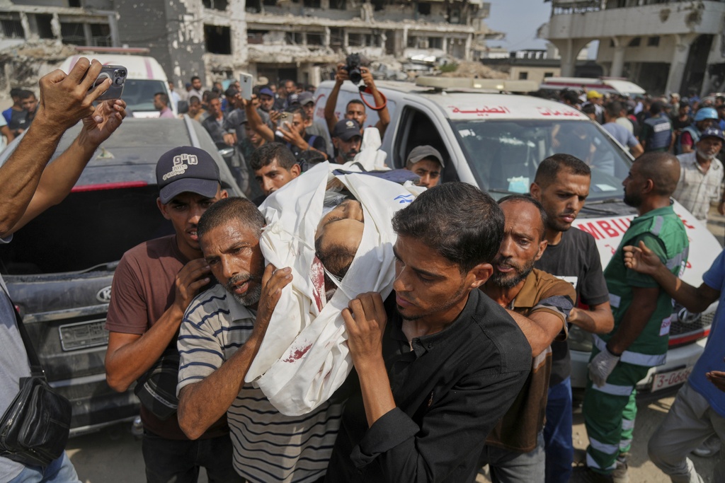 Palestinians carry the body of Al Jazeera journalist Mohamed Qreiqeh, one of five Al Jazeera staff members killed in a targeted Israeli drone strike, during his funeral outside Gaza City's Shifa Hospital complex on Monday, Aug. 11, 2025. (AP Photo/Jehad Alshrafi)