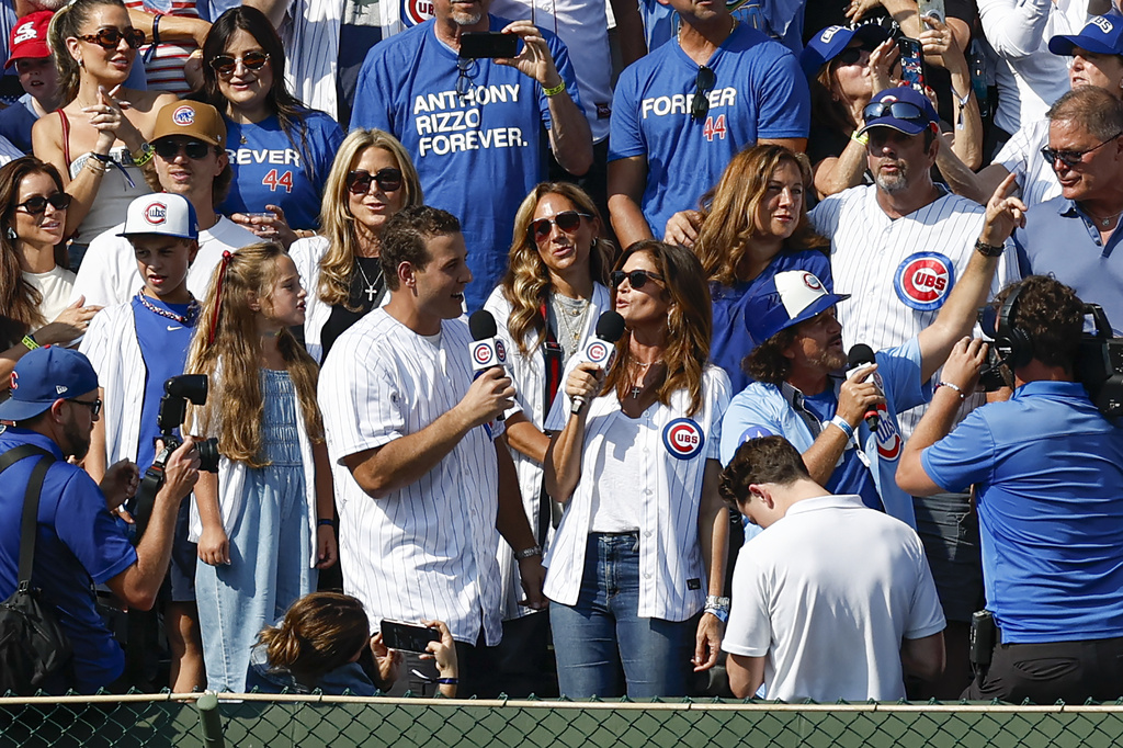 Former Chicago Cubs player Anthony Rizzo sings from the bleachers with Cindy Crawford and Eddie Vedder during the seventh inning stretch during a baseball game between the Chicago Cubs and Tampa Bay Rays Saturday, Sept. 13, 2025, in Chicago. (AP Photo/Kamil Krzaczynski)