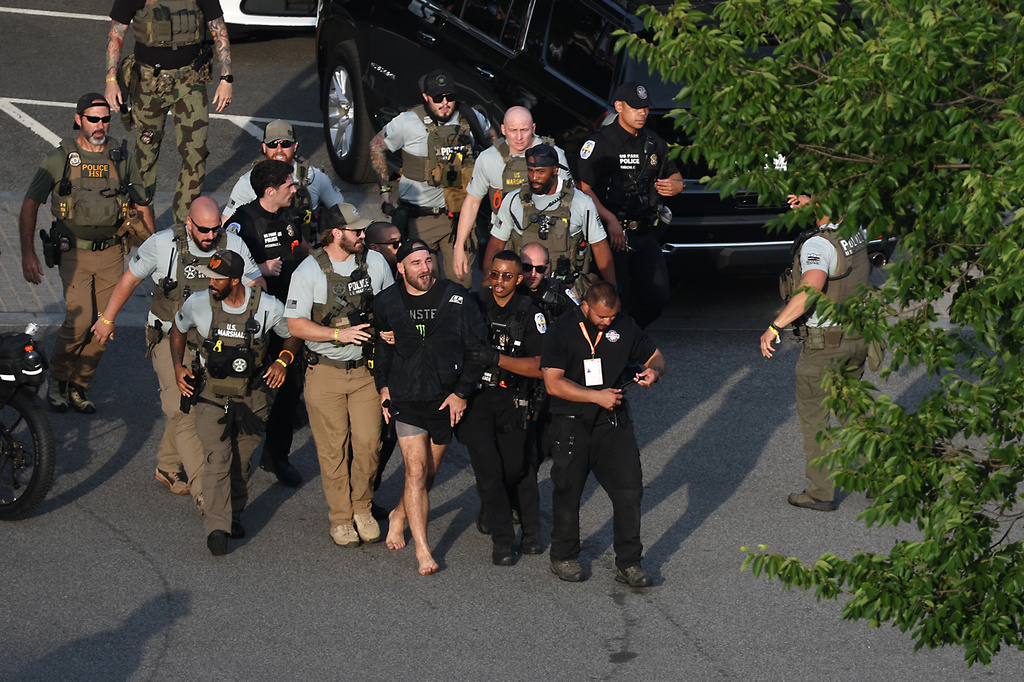 MMA fighter Sean Strickland is escorted out of the UFC Freedom 250 Fan Fest on The Ellipse by U.S. Secret Service and other law enforcement ahead of UFC Freedom 250 on the South Lawn of the White House on Sunday, June 14, 2026, in Washington. (Kevin Dietsch/Pool Photo via AP)