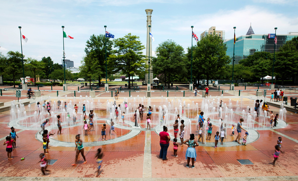 FILE - In this Friday, July 22, 2016 photo, people play in the fountains shaped by the Olympic rings at Centennial Olympic Park in Atlanta. (AP Photo/David Goldman, File)