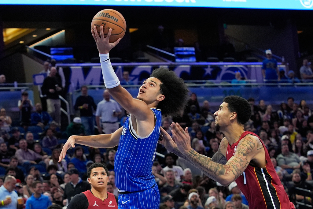 Orlando Magic guard Anthony Black shoots as he gets past Miami Heat center Kel'El Ware, right, during the second half of an NBA basketball game, Friday, Dec. 5, 2025, in Orlando, Fla. (AP Photo/John Raoux)