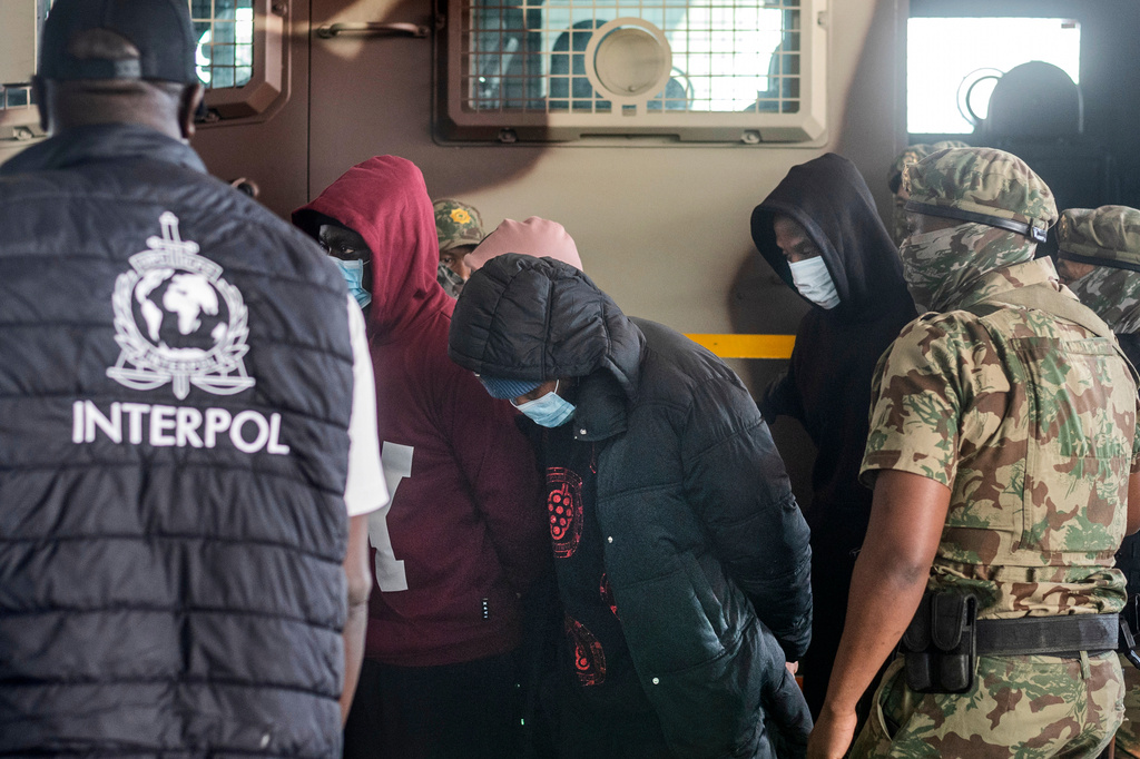Members of the elite tactical police unit escort six Nigerians nationals being extradited to US for participating in romance scams, in Cape Town, South Africa, Friday, Sept. 11, 2026. (AP Photo)