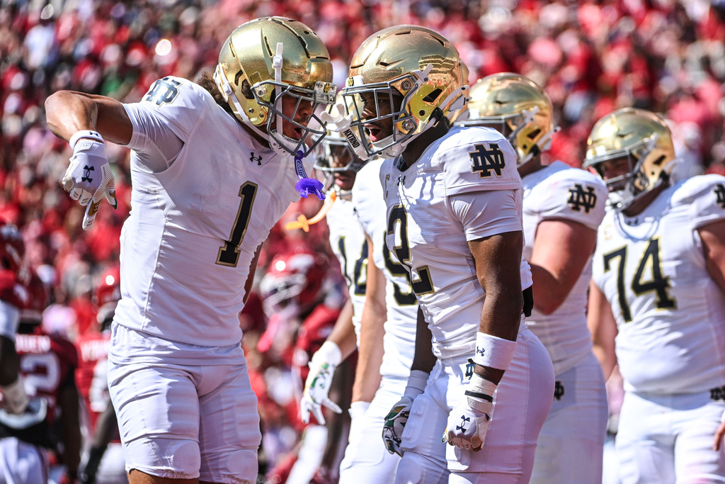 Notre Dame players Jaden Greathouse (1) and Will Pauling (2) celebrate after Pauling caught a touchdown pass against Arkansas during the first half of an NCAA college football game Saturday, Sept. 27, 2025, in Fayetteville, Ark. (AP Photo/Michael Woods)