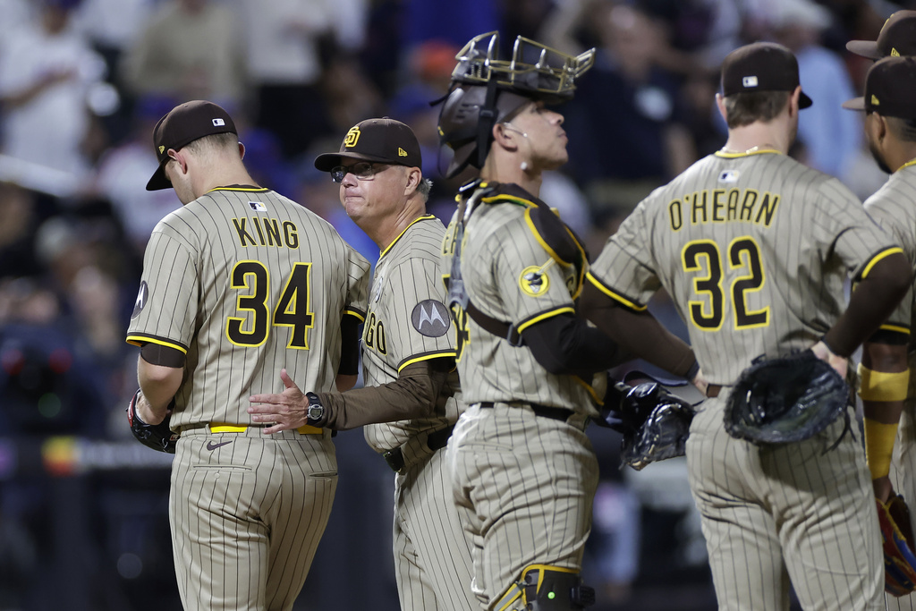 San Diego Padres manager Mike Shildt, second left, pats Michael King (34) on the back as he walks off the mound during the fourth inning of a baseball game against the New York Mets, Tuesday, Sept. 16, 2025, in New York. (AP Photo/Adam Hunger)